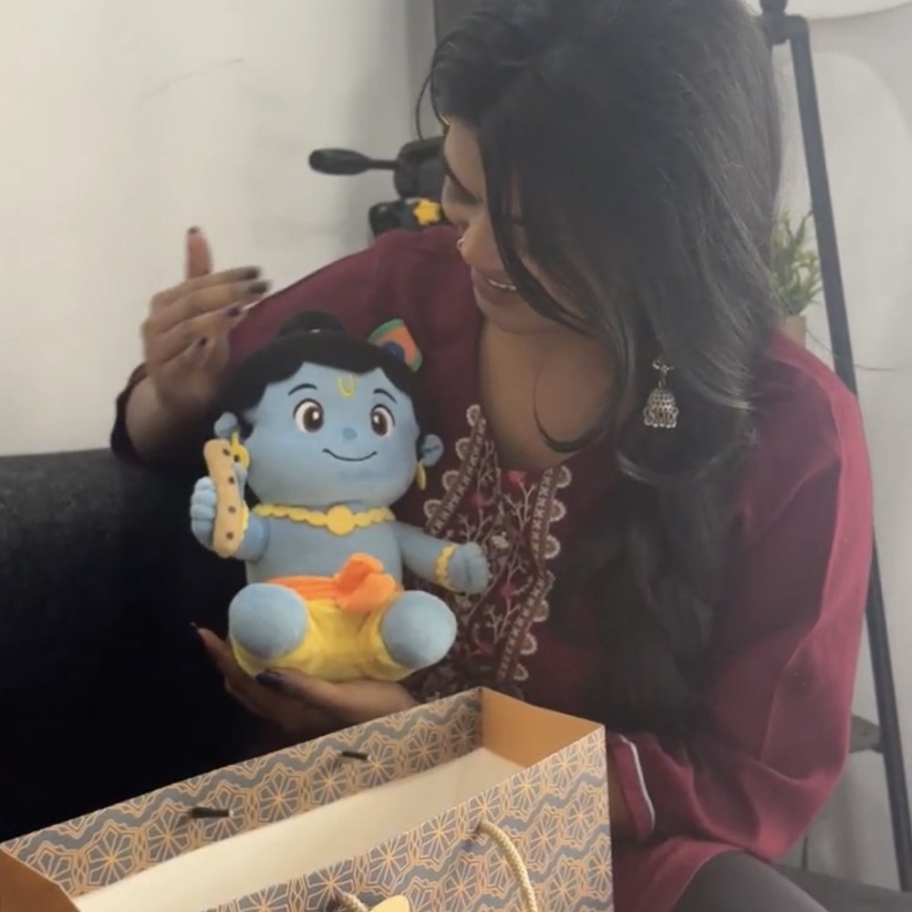 Customer unboxing the Krishna plush from its gift bag
